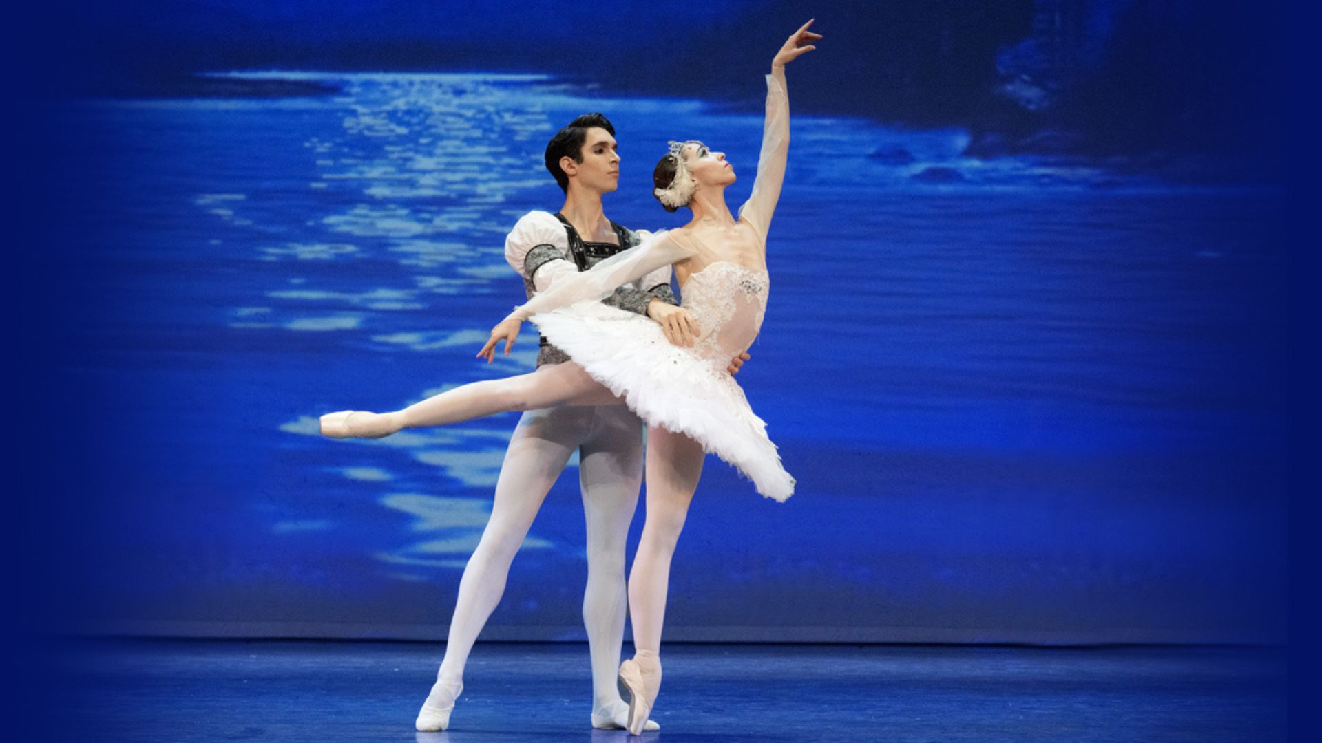 Male ballet dancer with his arms around female dancer En ponte dressed in a tutu 